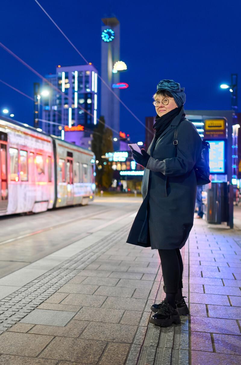 Nainen seisoo Tampereen rautatieasemalla.